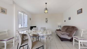 Un espace repas comprenant une table, des chaises et un luminaire suspendu.