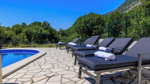 Un espace aménagé au bord de la piscine, avec des chaises longues et une piscine.