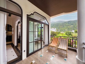 A balcony with a view of a green landscape, a sliding glass door, and a chair. - Natalie Indochine Mountain Villa Da Nang By Sujet of Haviland (Da Nang)