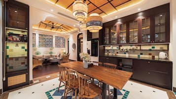 Una cocina moderna con armarios oscuros, una mesa de comedor de madera y un suelo con estampado.