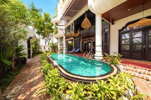 A swimming pool with a tiled edge, surrounded by lush greenery and a brick pathway. - Natalie Indochine Mountain Villa Da Nang By Sujet of Haviland (Da Nang)
