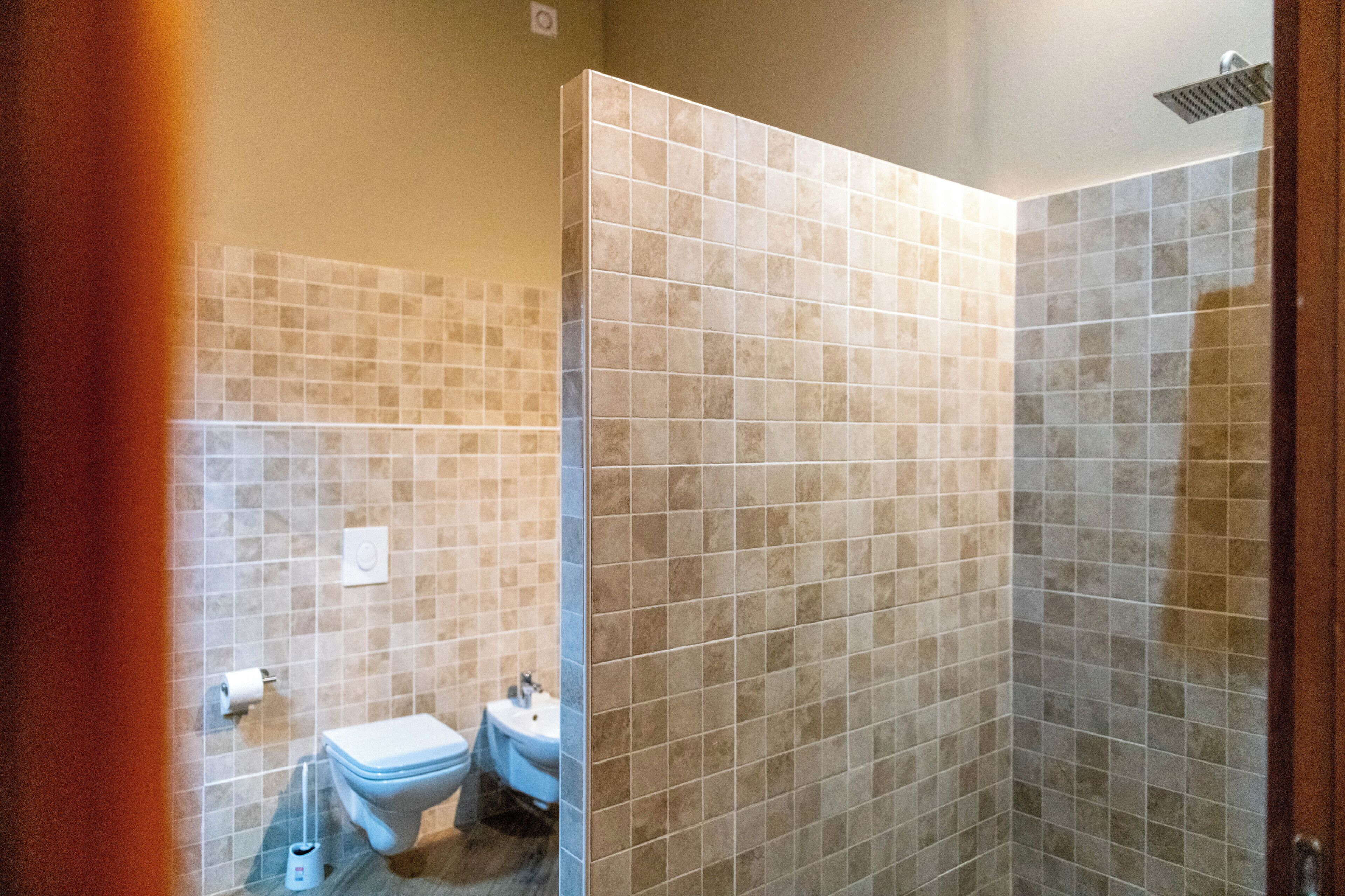 A bathroom with a toilet, sink, and shower area.