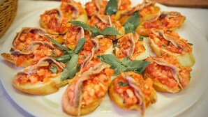 Un piatto di antipasti con pane, pomodoro e basilico.