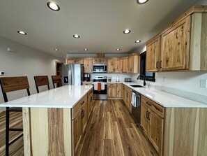 Une cuisine moderne avec des meubles en bois, des appareils électroménagers en acier inoxydable et un îlot central.