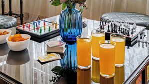 Ein Zimmer mit einem für ein Spiel gedeckten Tisch, einer Blumenvase und Blick durch durchscheinende Vorhänge.