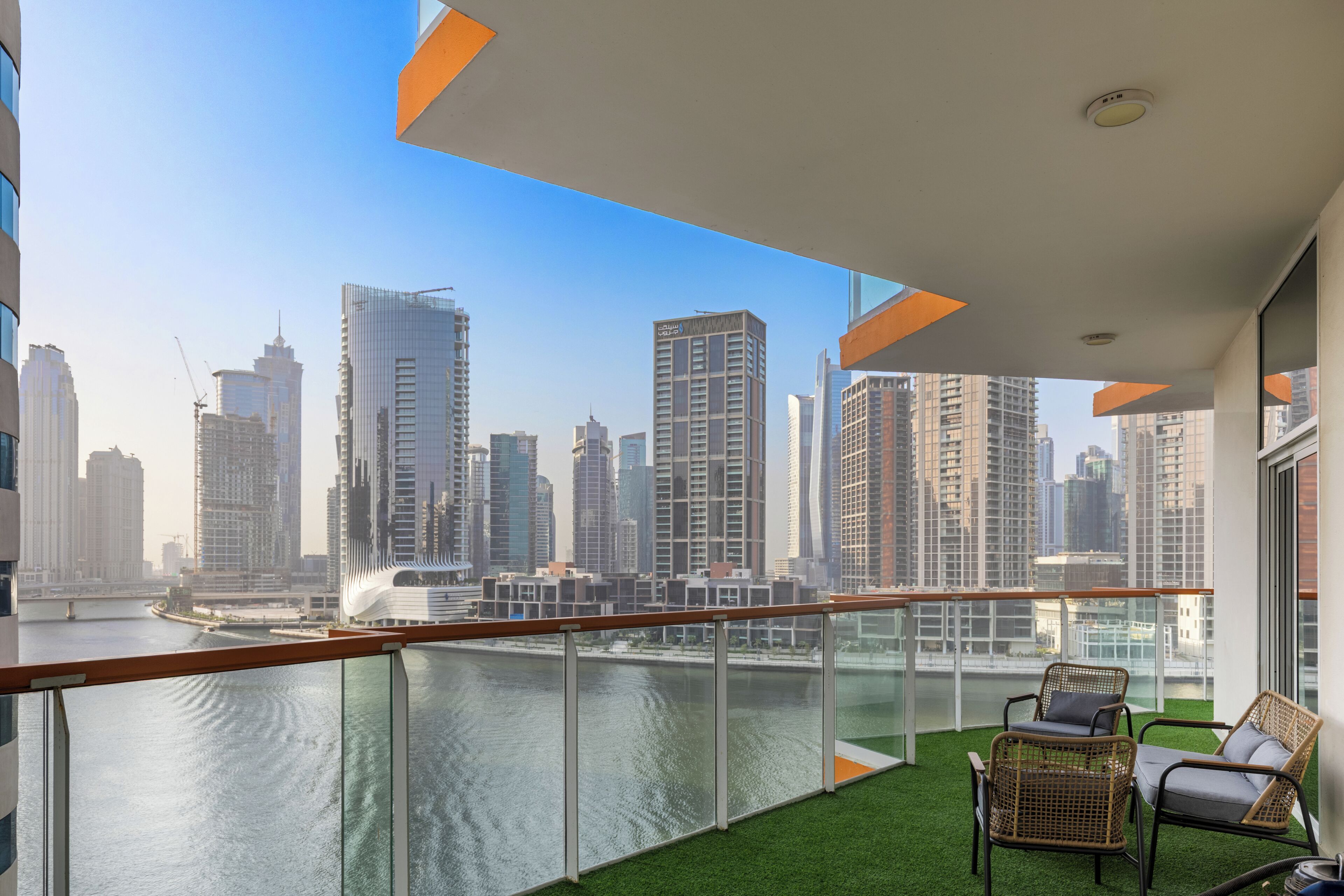A balcony with a view of a city skyline and a river.