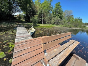 A wooden dock extending into a calm body of water with a rowboat moored at the end. - Outback Shack: Lake Access Studio in Woodruff (Woodruff)