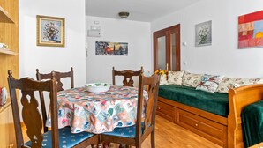 A room with a dining table, chairs, a sofa, and a bed. - Apartment 'Carmina El Fondon 3' with Balcony and Wi-Fi (Cangas de Onís)