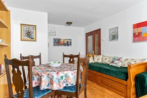 Una habitación con una mesa de comedor, sillas, un sofá y una cama.