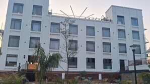 Un hôtel à plusieurs étages, doté d’une façade blanche, de nombreuses fenêtres et d’un balcon.