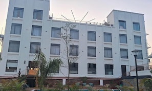 Ein mehrstöckiges Hotel mit einer symmetrischen Fassade, großen Fenstern und einem zentralen Eingang.