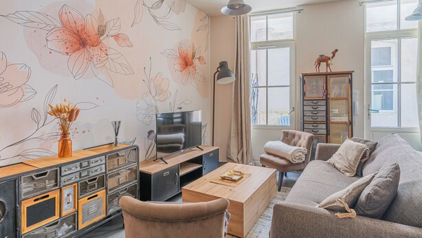 A living room with a sofa, coffee table, TV, and a cabinet with drawers. - Nid du marché downtown La Rochelle, wifi (La Rochelle)