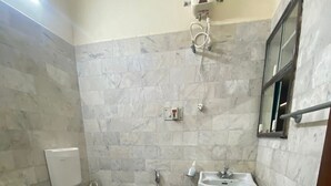 Un baño con inodoro, lavabo y ducha.