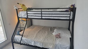 Un letto a castello con materasso, cuscini e peluche.