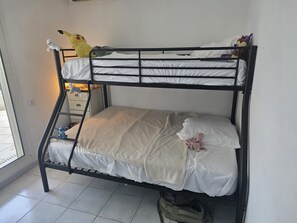 Ein Etagenbett mit einer Matratze, Kissen und Stofftieren.
