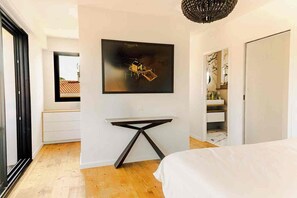 A modern bedroom with a bed, a desk, and a large artwork on the wall. - Luxurious Villa Chiberta • Pool • 5 suites • Golf & Beach (Anglet)