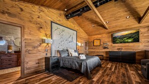 Une chambre à coucher aux murs lambrés, avec un lit, une commode et un téléviseur.