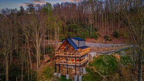 Une cabane en bois dotée d’un balcon, entourée d’arbres.