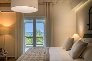 A bedroom with a bed, pillows, a lamp, a view of the sea, and a balcony. - Rivazzurra Luxury Villa, Villa (Lithakia)
