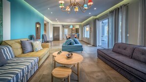 Ein modernes Wohnzimmer mit einer Couch, einem Esstisch und einer Deckenleuchte.