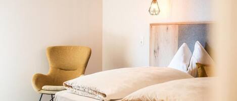 Una camera da letto con un letto, una poltrona a dondolo e un lampadario.