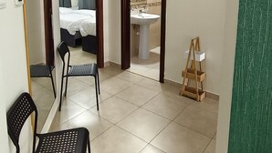 A hotel room with a bed, a bathroom, a mirror, and a chair. - Dubai gate-2 (Dubai)