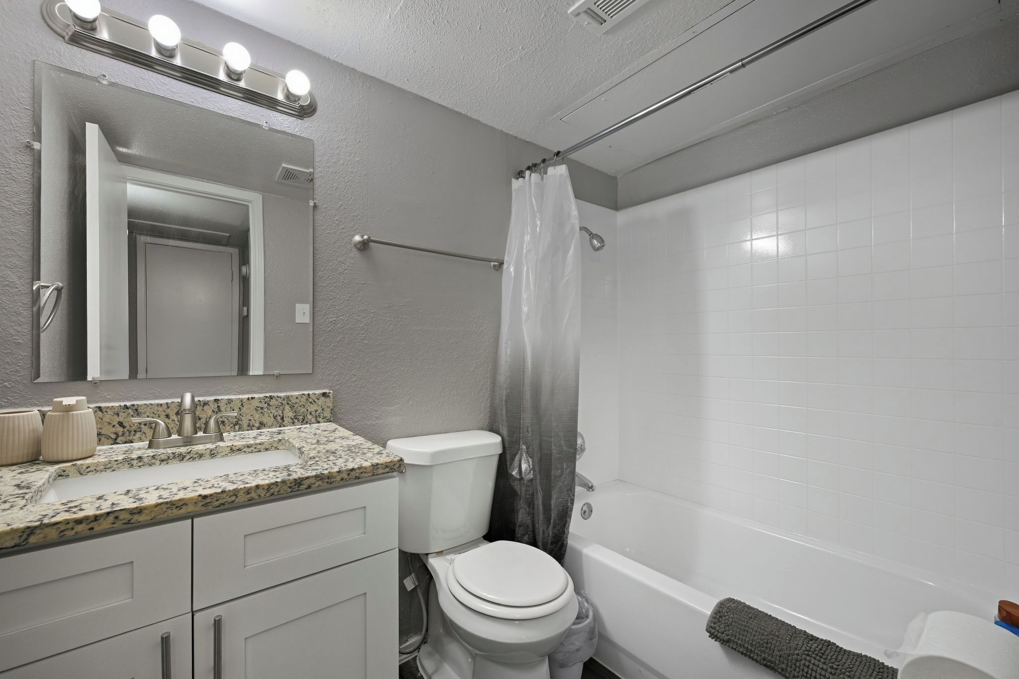 Ein Badezimmer mit Waschbecken, Toilette, Badewanne und Duschvorhang.