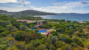 Una propiedad costera con piscina rodeada de exuberante vegetación y vistas al mar.