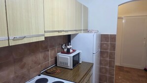 Une cuisine compacte équipée d’un four à micro-ondes, d’une cuisinière et d’un réfrigérateur.