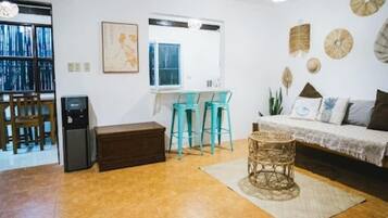 A living room with a sofa, a coffee table, and a dining area with chairs.