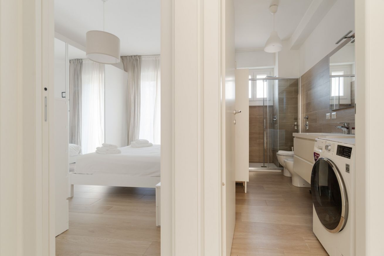 Une chambre d’hôtel équipée d’un lit, d’une douche, de toilettes et d’une machine à laver.