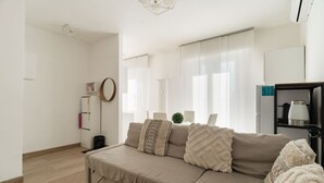 A modern living room with a beige sofa, a coffee table, and a bookshelf. - GuestHost - Spacious 90m2 apartment, ideal for up to 6 people, located on the fourth floor of a building with lift.The accommodation is located in Municipality 4, within the Forlanini/Mecenate district, in the eastern area of ​​Milan, a predominantly (Milan)