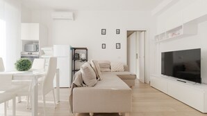 A modern living room with a sofa, TV, and kitchen area. - GuestHost - Spacious 90m2 apartment, ideal for up to 6 people, located on the fourth floor of a building with lift.The accommodation is located in Municipality 4, within the Forlanini/Mecenate district, in the eastern area of ​​Milan, a predominantly (Milan)