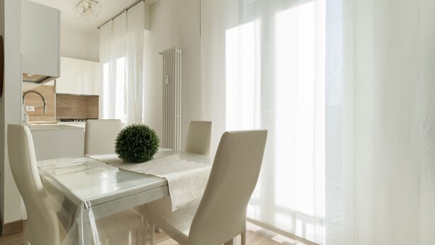A modern kitchen with white cabinets, a stainless steel range hood, and a window with sheer curtains. - GuestHost - Spacious 90m2 apartment, ideal for up to 6 people, located on the fourth floor of a building with lift.The accommodation is located in Municipality 4, within the Forlanini/Mecenate district, in the eastern area of ​​Milan, a predominantly (Milan)