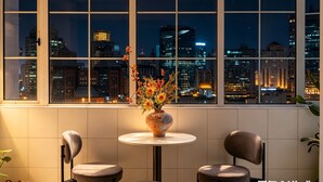 A room with a large window, a vase with flowers, and two chairs. - Pine  Cedar Suites Hua Xiao Ye (Shanghai)