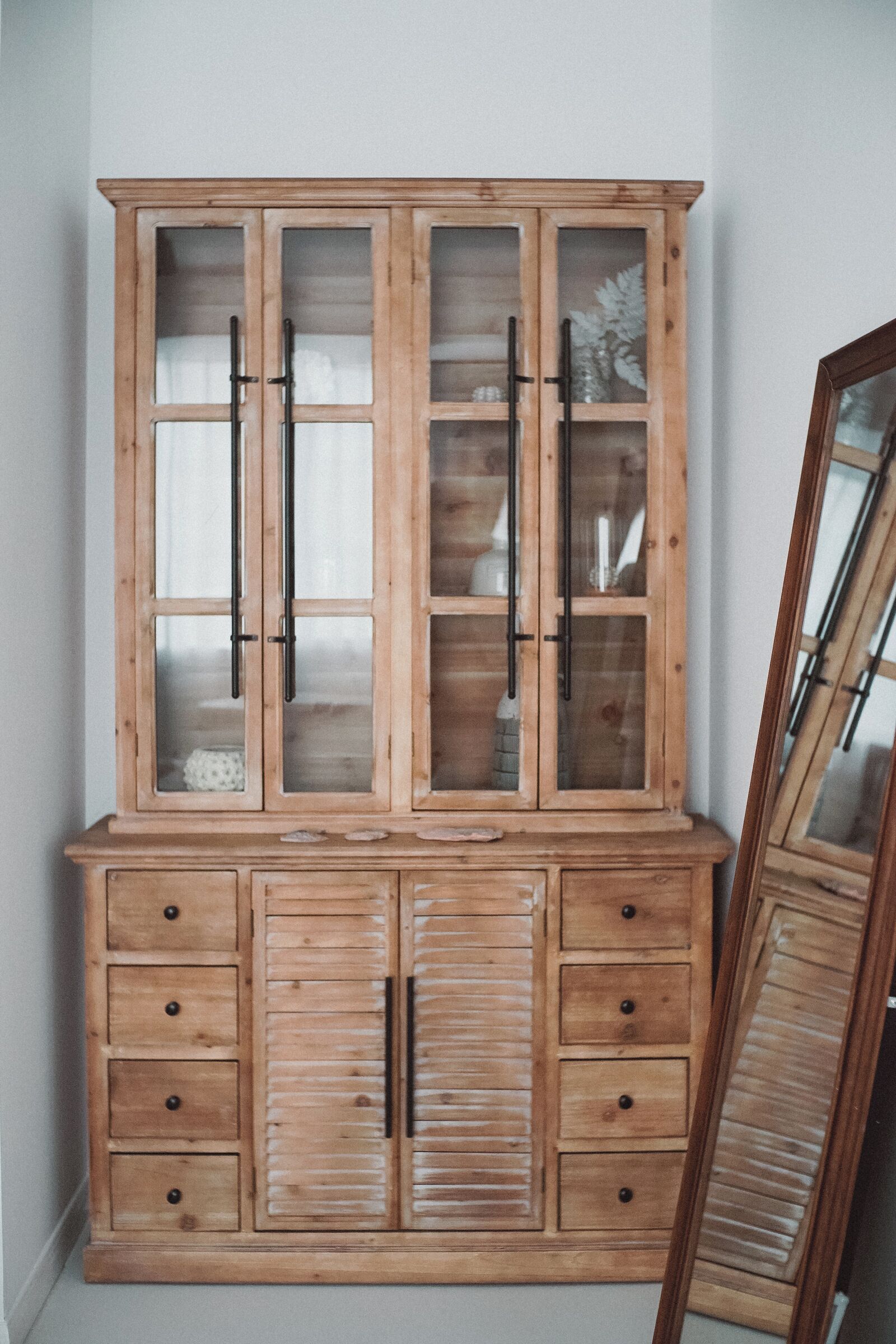 Un meuble en bois doté de portes et de tiroirs en verre.