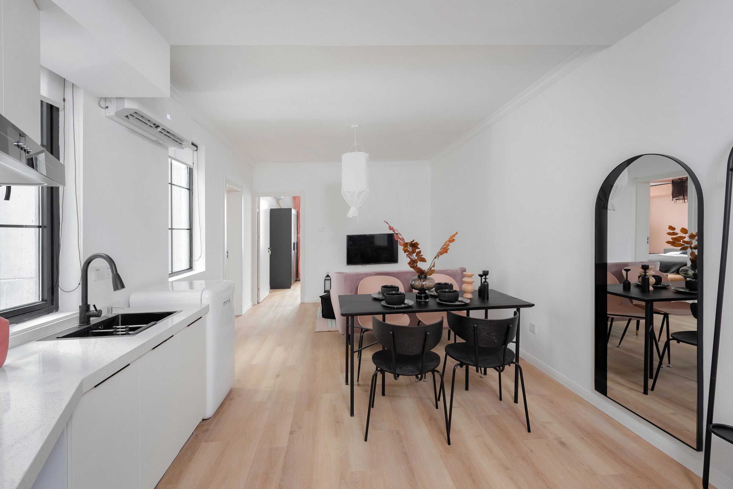 A modern kitchen with a built-in sink and a dining area with a table and chairs.