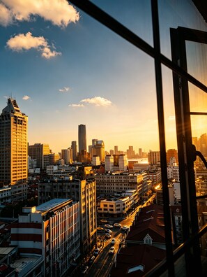 Stadsbeeld met hoge gebouwen, een rivier en een zonsondergang.