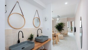 A modern bathroom with two grey sinks, wooden vanity, and a round mirror. - Pine  Cedar Suites Hua Xiao Ye (Shanghai)