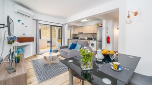 A modern apartment with a dining area, kitchen, and a balcony with a view. - Apartment 'Madalena' with Private Pool, Wi-Fi and Air Conditioning (Carvoeiro)