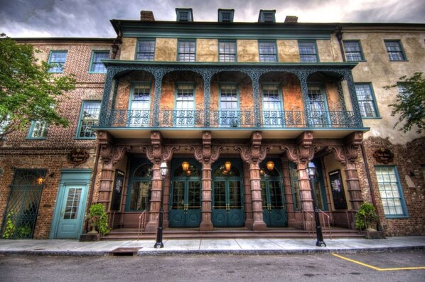A historic building with a prominent entrance, large windows, and ornate architectural details.