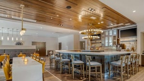 Una cocina moderna con barra, techo de madera y comedor con mesa de mármol.
