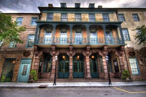 Un edificio histórico con una entrada destacada, ventanas amplias y detalles arquitectónicos ornamentados.