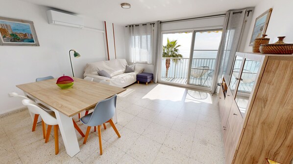 Un salon moderne avec une table à manger en bois, un canapé blanc et un balcon offrant une vue agréable.