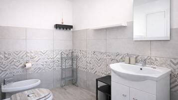 A bathroom with two sinks, a mirror, a towel rack, and patterned tiles.