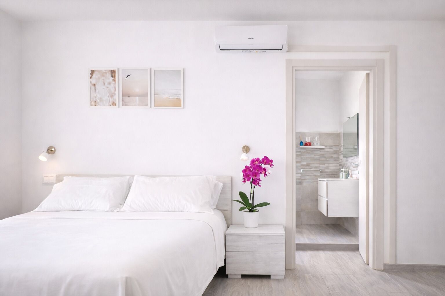 Un dormitorio con cama, mesita de noche y una orquídea en maceta.