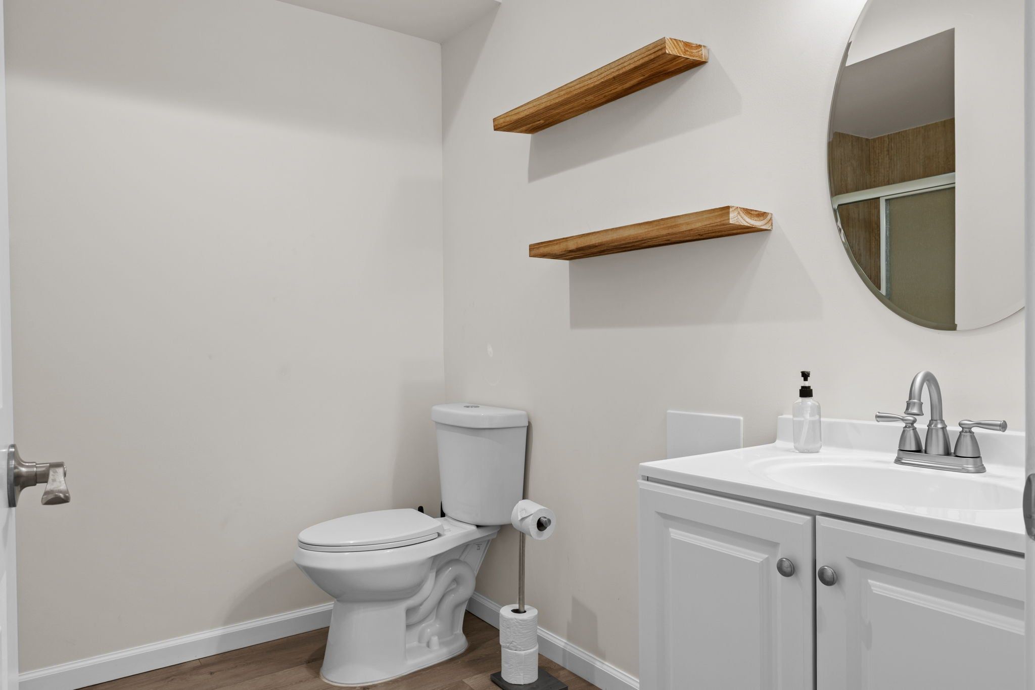 Une salle de bain avec des toilettes, un lavabo et un miroir.