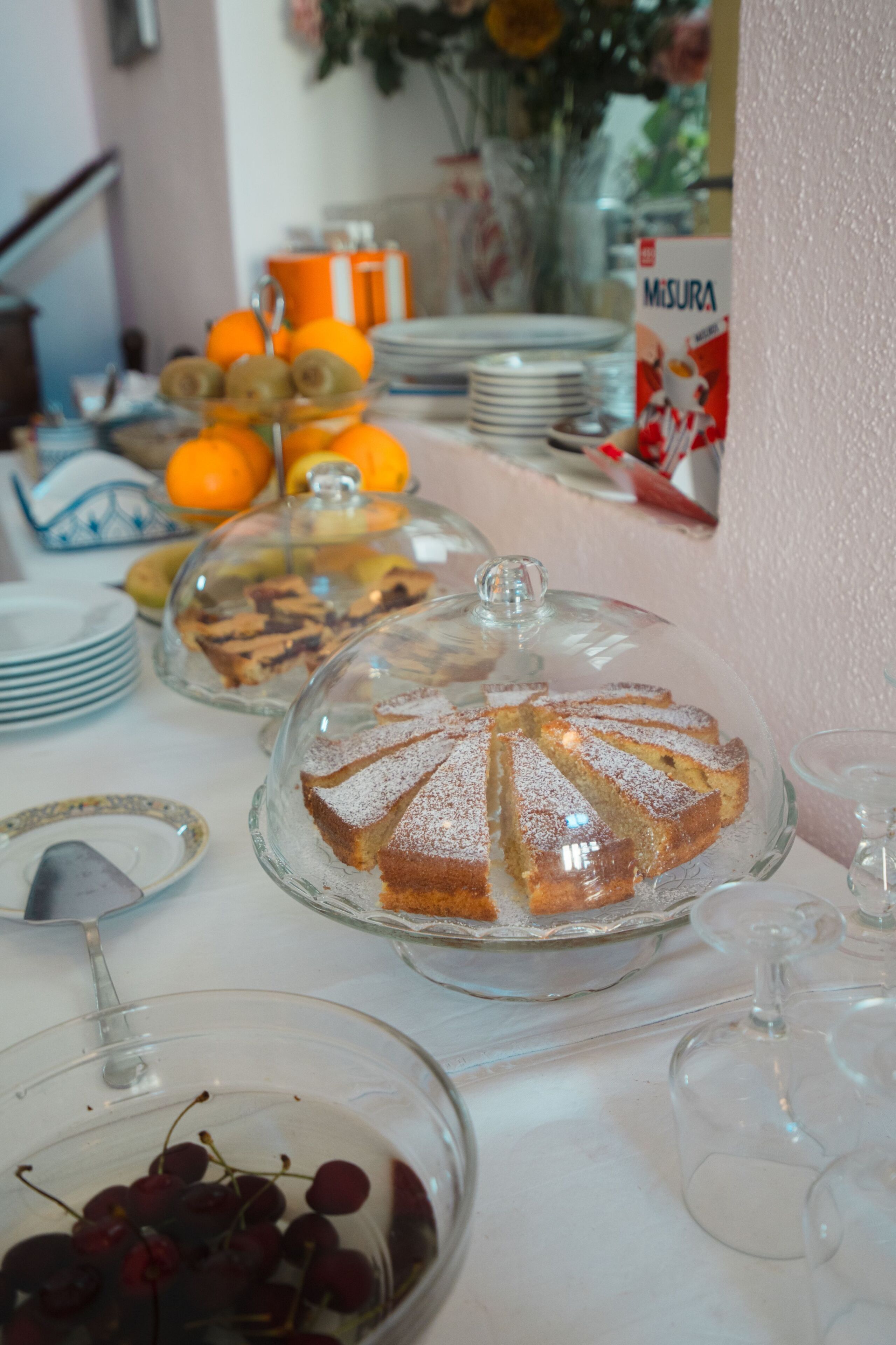 A dining table with various food items and glassware.