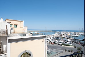 Ein Yachthafen mit Booten, blauem Himmel und einem Gebäude mit Balkon.