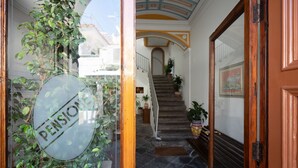 A staircase leading to a second floor with a glass door on the left.